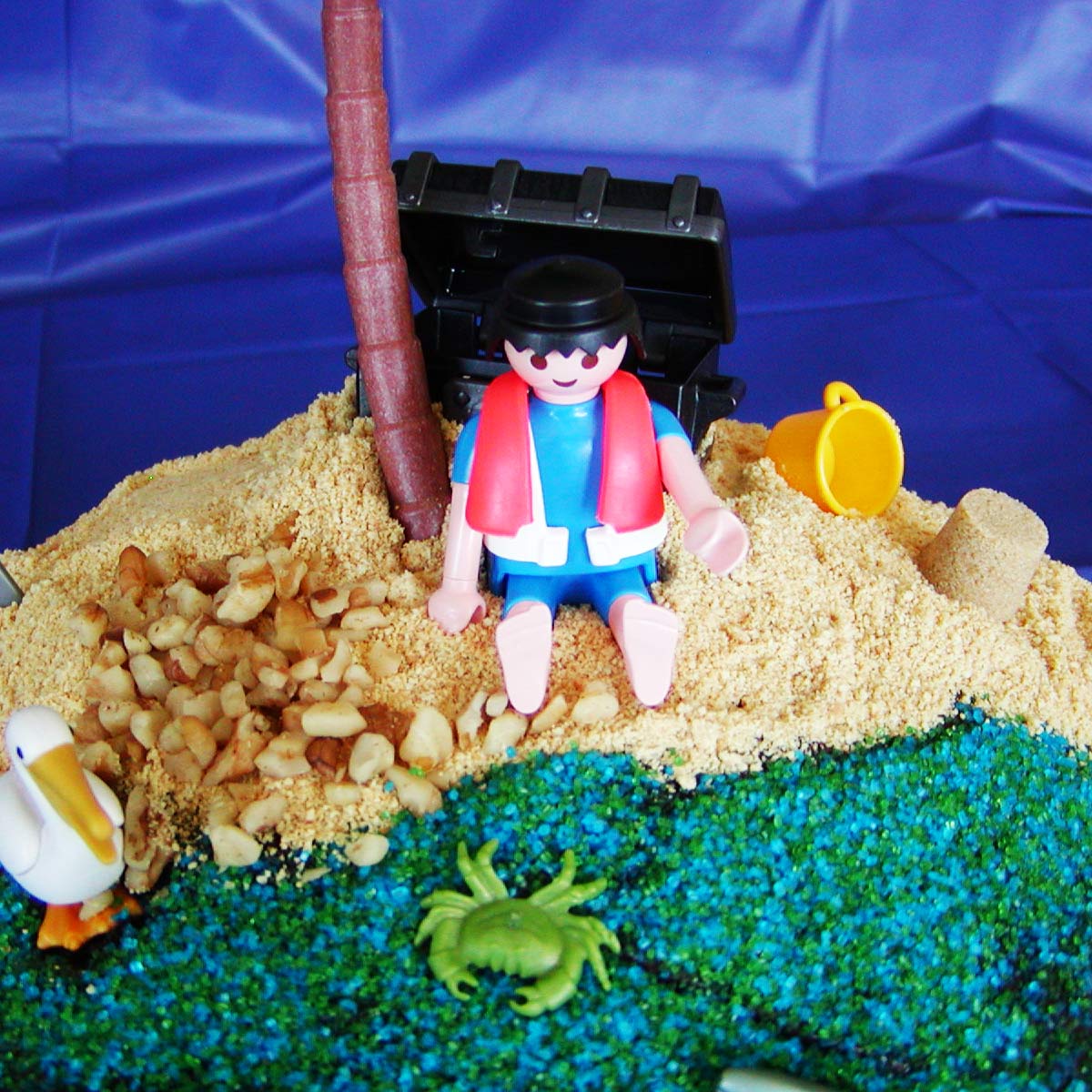beach cake closeup of lifeguard on beach with pelican and crab toys.