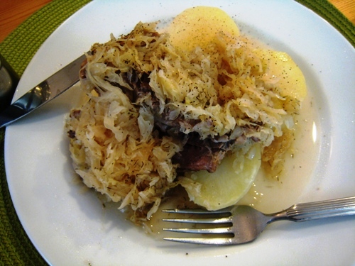 A plate of Sauerkraut and Pork with fork