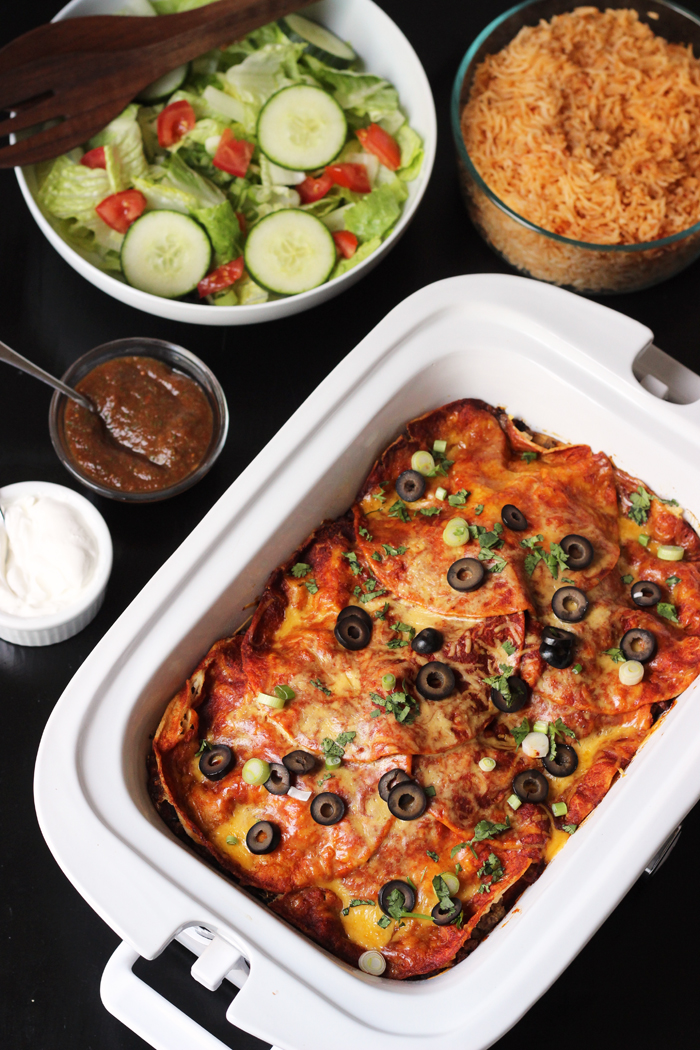 table set with enchiladas, salad, and rice