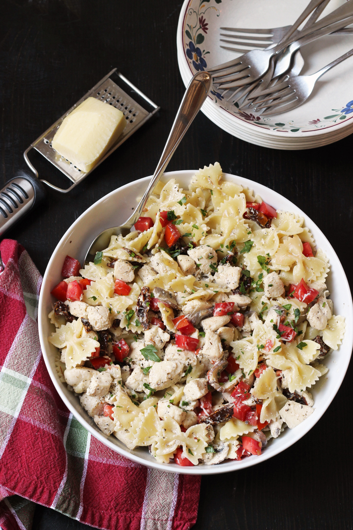 A bowl of Chicken Bowtie Pasta, with cheese and grater