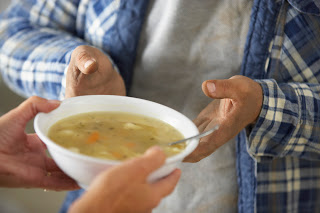 A person holding a bowl of soup