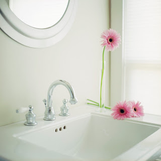A pink flower with a sink and a mirror.