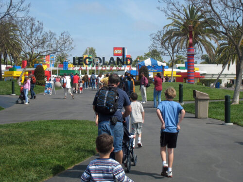 A group of people walking into Legoland.