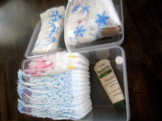 A plastic container filled with diapers, wipes, and lotion.