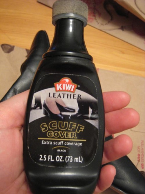 Hand holding a bottle of scuff cover.