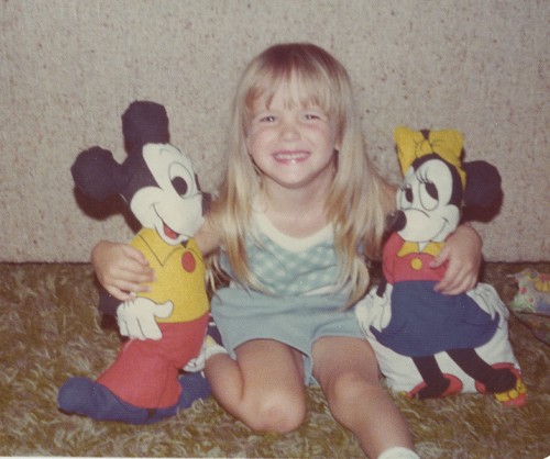 Vintage image of Jessica holding Mickey and Minnie dolls.