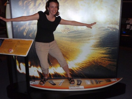 A mom standing on a surf board at Maritime Museum in Santa Barbara.