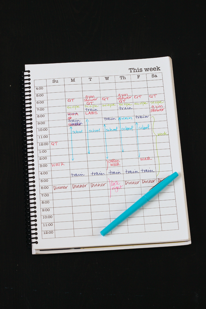 overhead view of time blocked weekly calendar with blue pen.