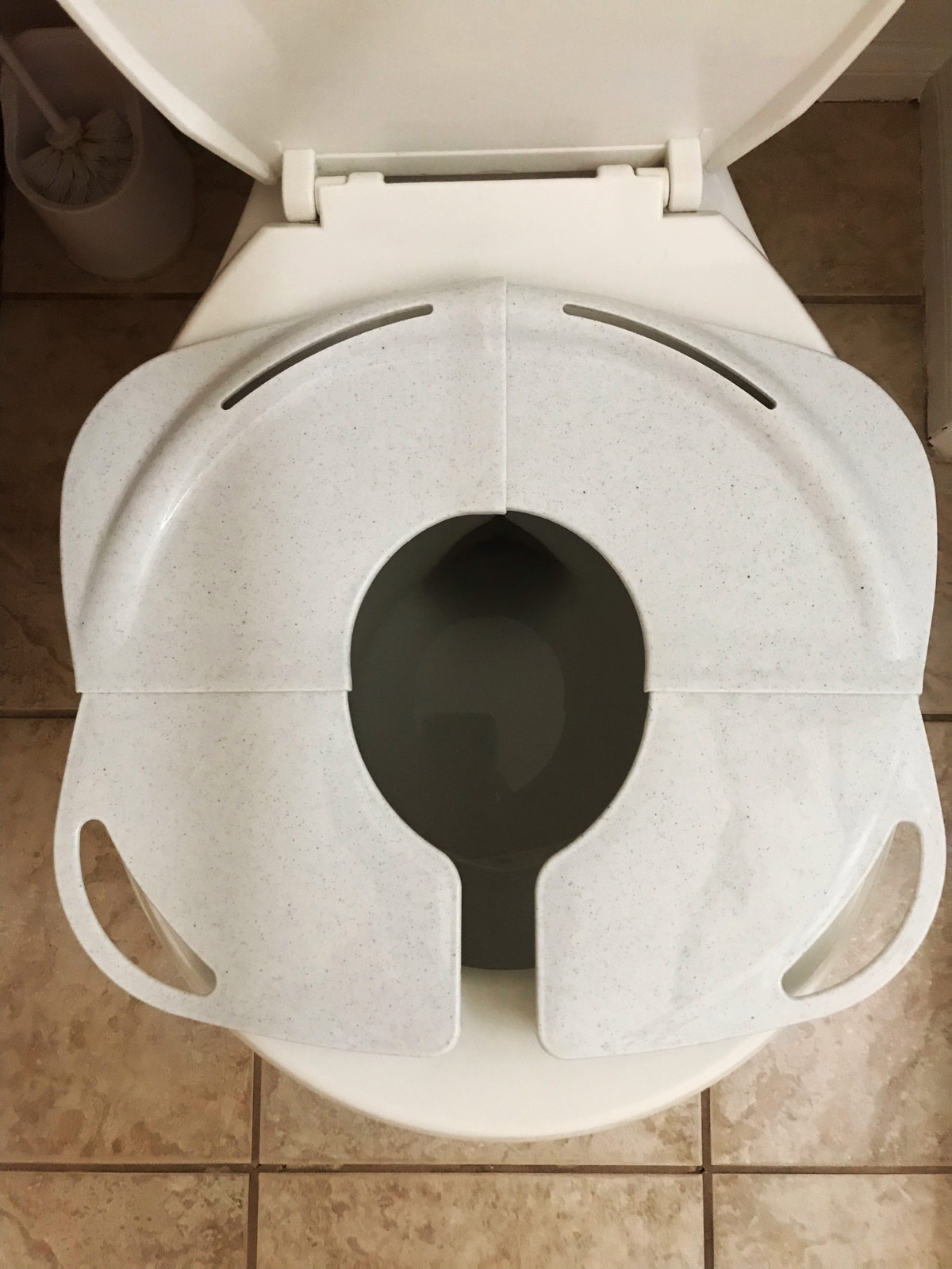 travel potty training toilet seat fitted onto home toilet.