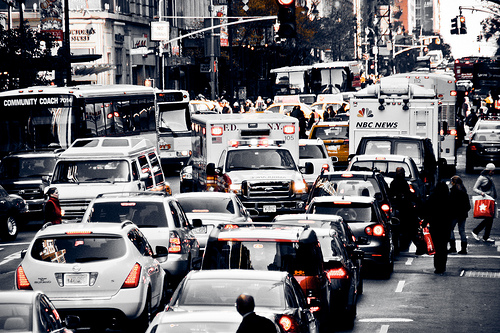 A close up of a busy city street filled with lots of traffic.