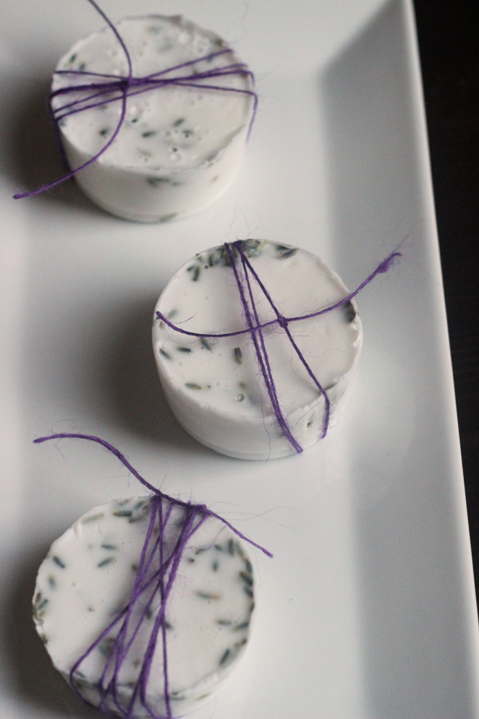 rounds of lavender soap, tied in purple twine on a white platter.