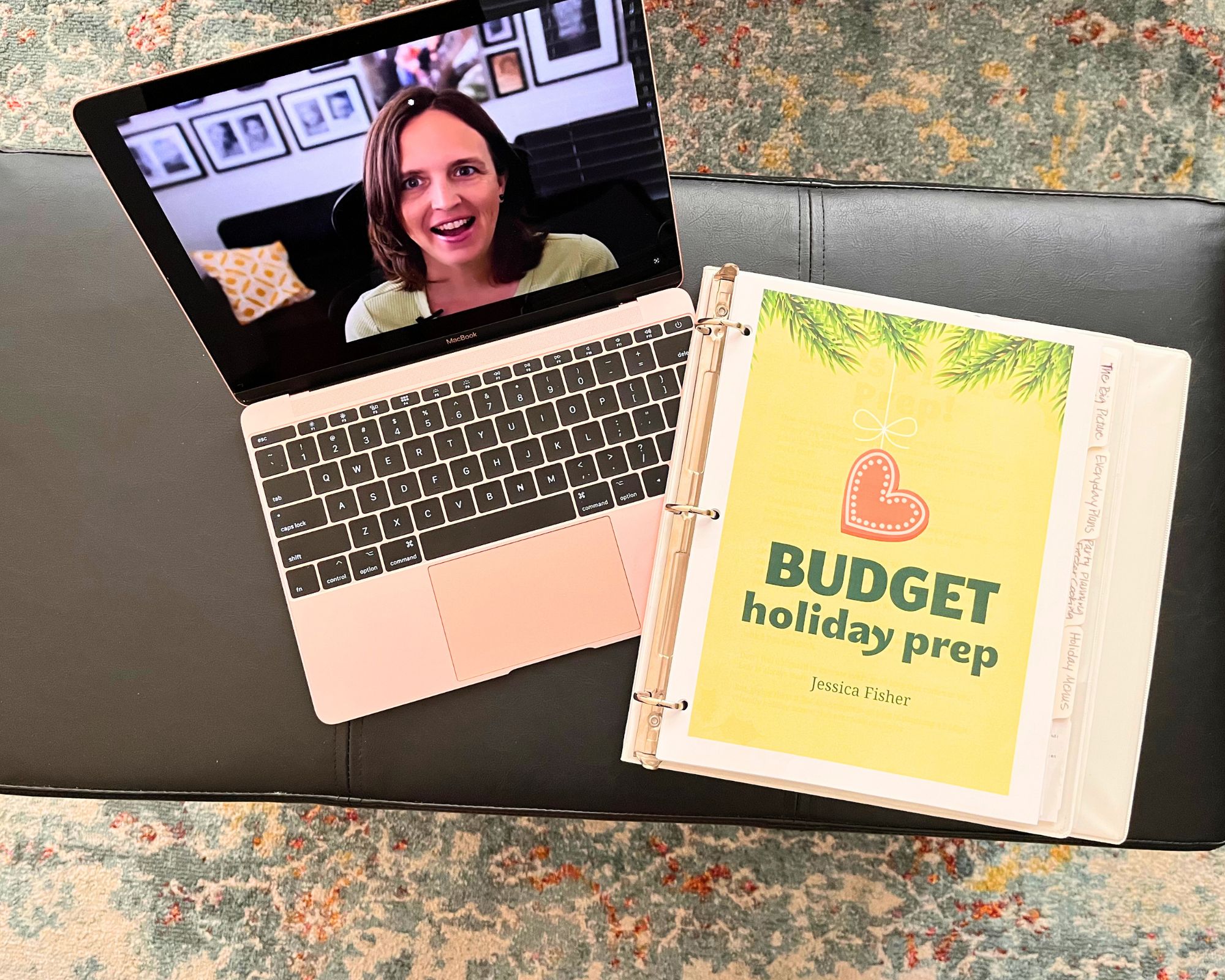 computer opened to a video next to a binder with budget holiday prep.