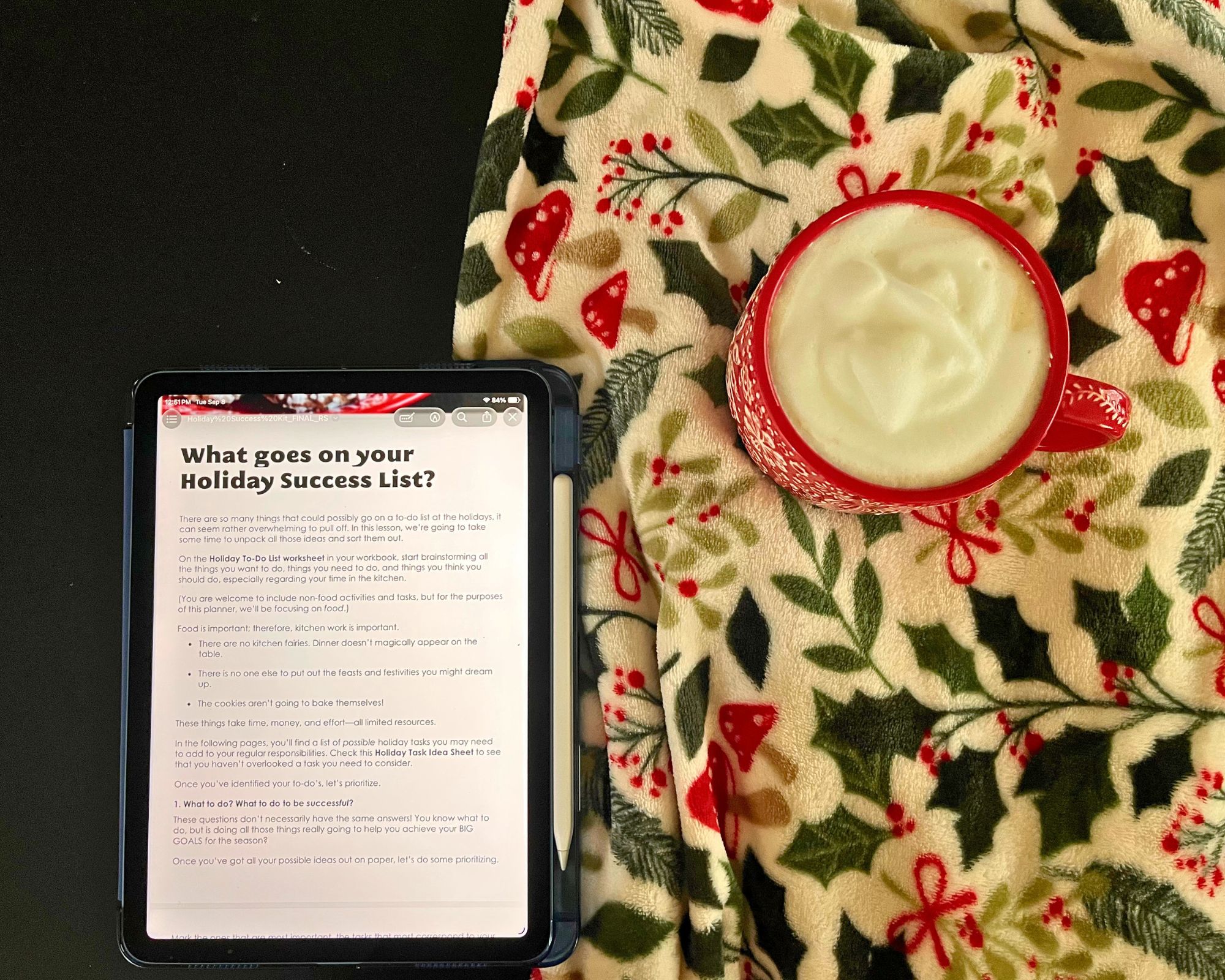 iPad open to holiday success kit, with mug and holiday blanket nearby.