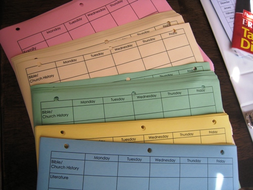 Colored assignment sheets laid out on table.