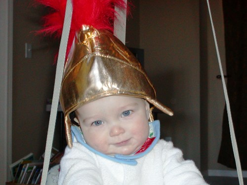 A baby boy wearing a Roman Centurion hat.