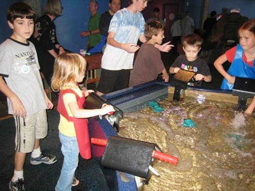 A group of kids and parents at the water table at Aquarium.