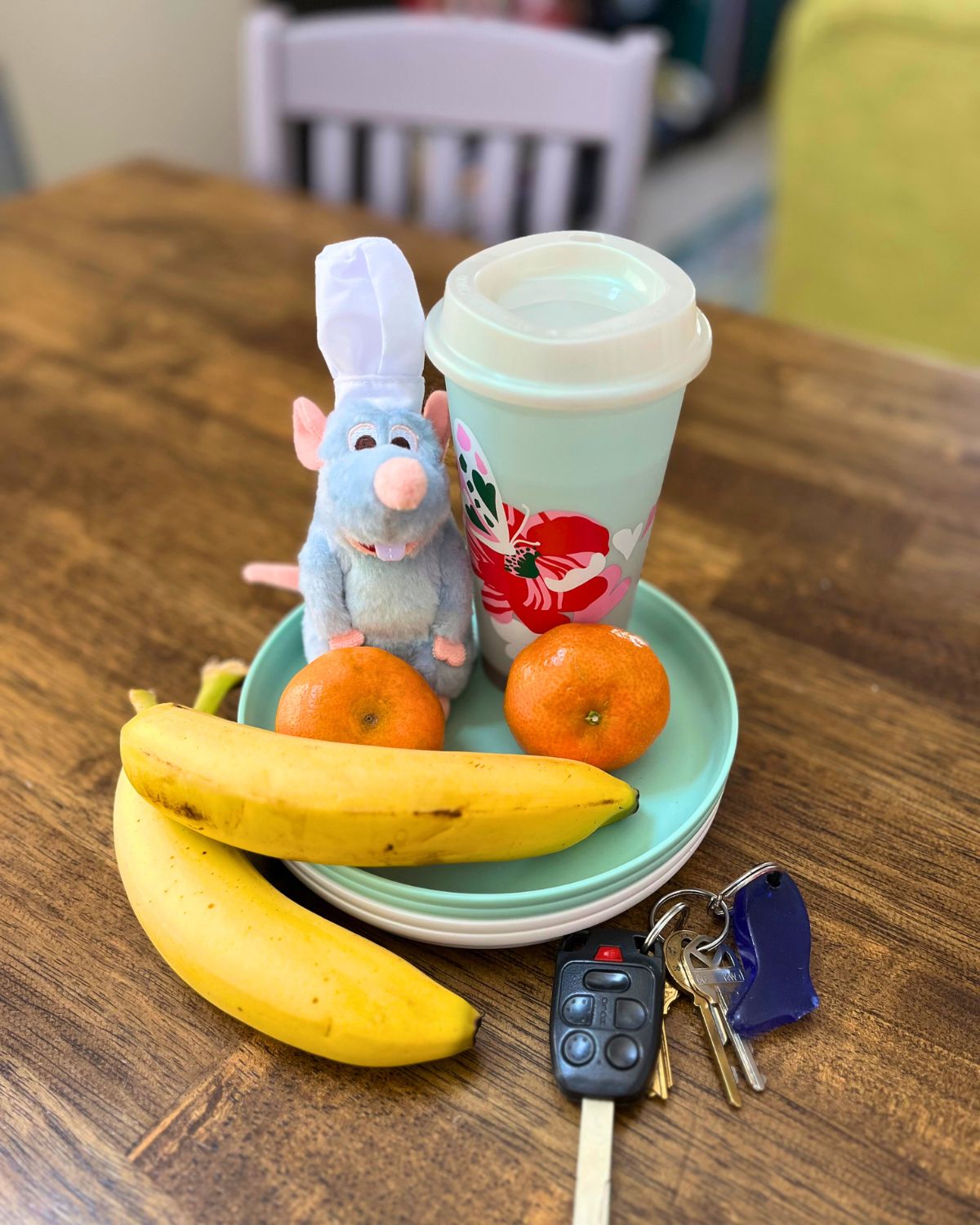 stuffed Remi oranges, bananas, plates, travel cup, and keys.