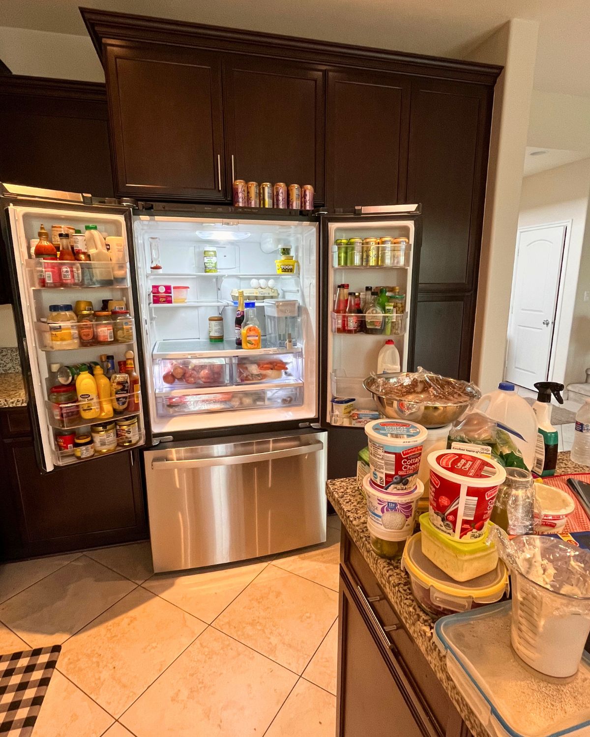 open fridge in process of contents being unloaded onto counter.