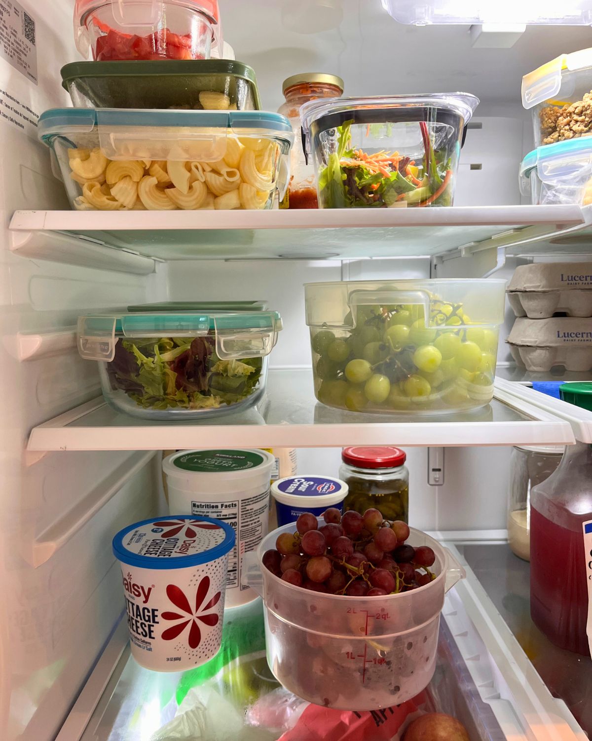 three shelves in fridge with prepped food.