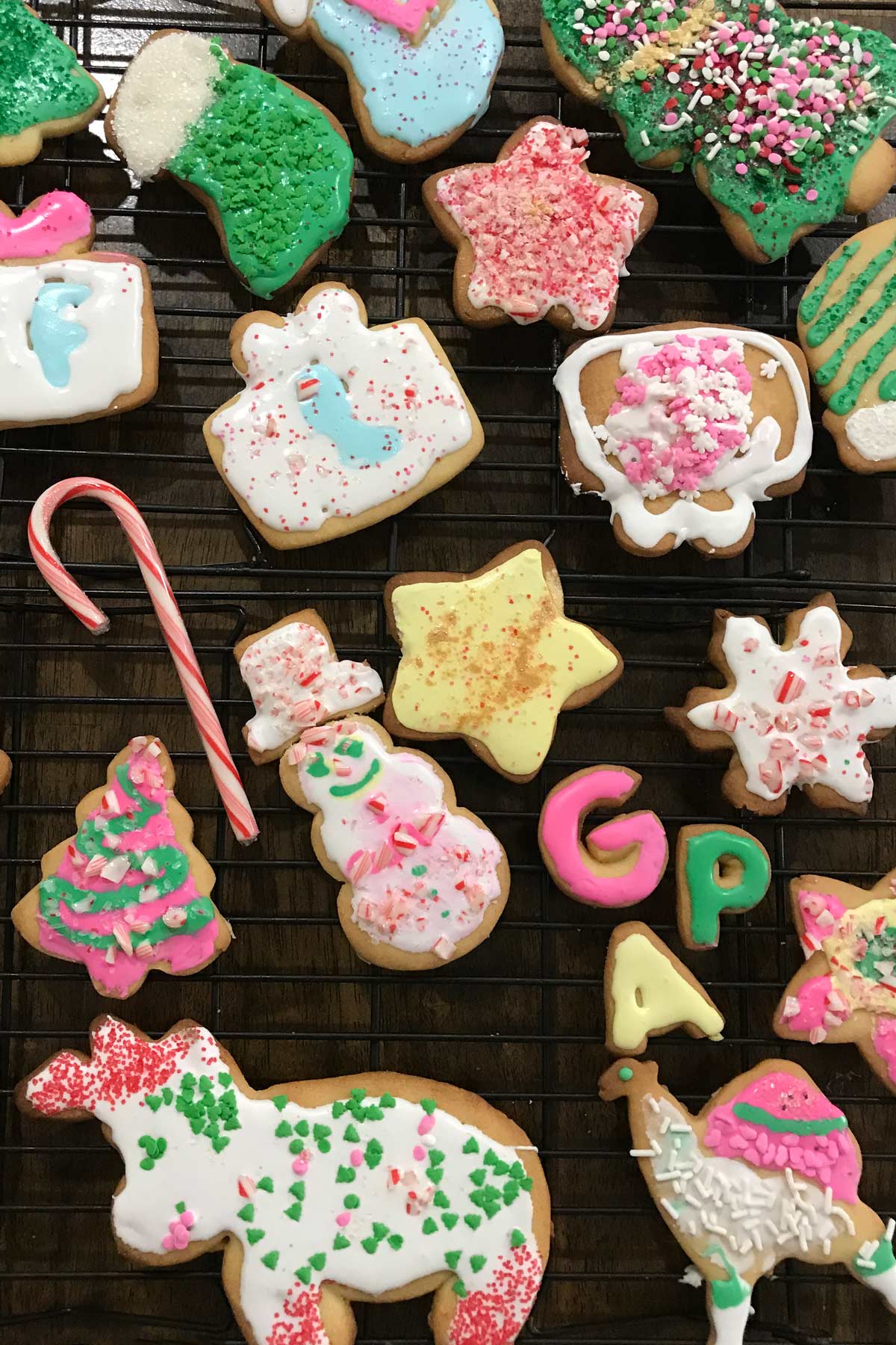 array of decorated christmas cookies on a wire rack.
