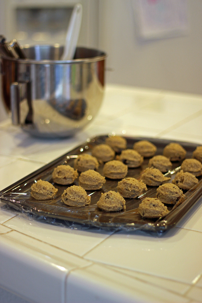 cookie dough balls on a lined tray for freezing