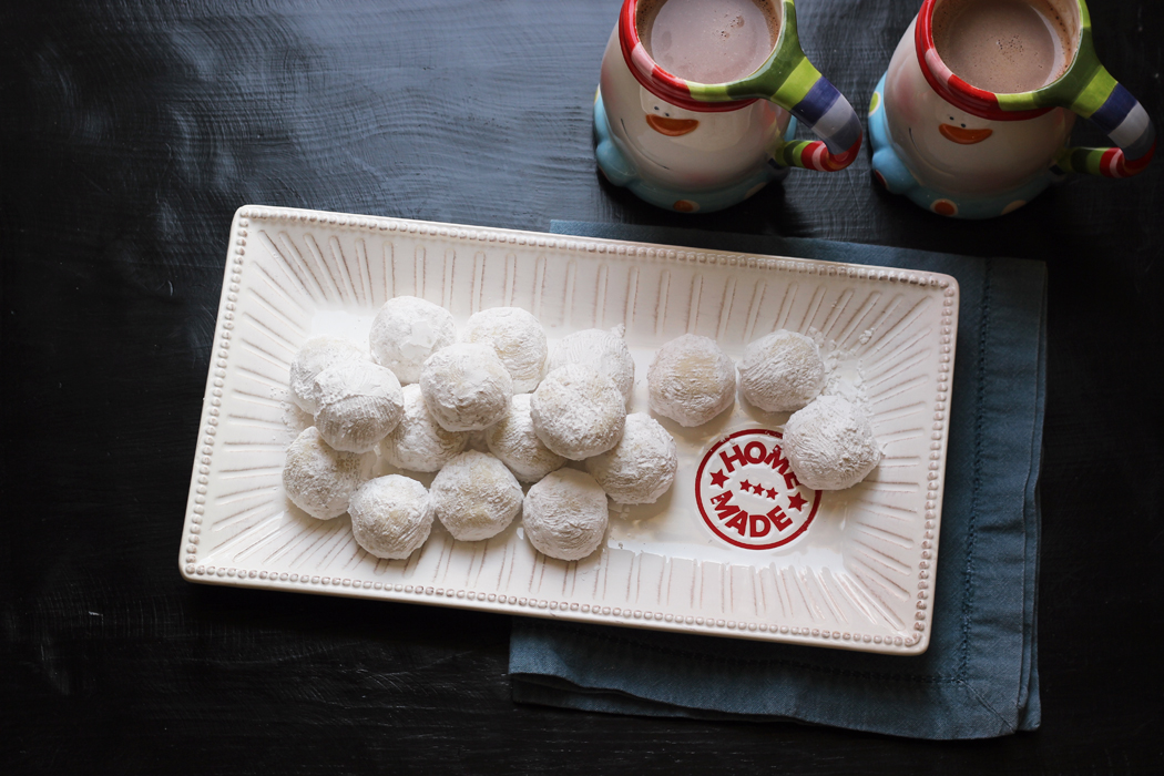 A tray of cookies next to mugs of cocoa