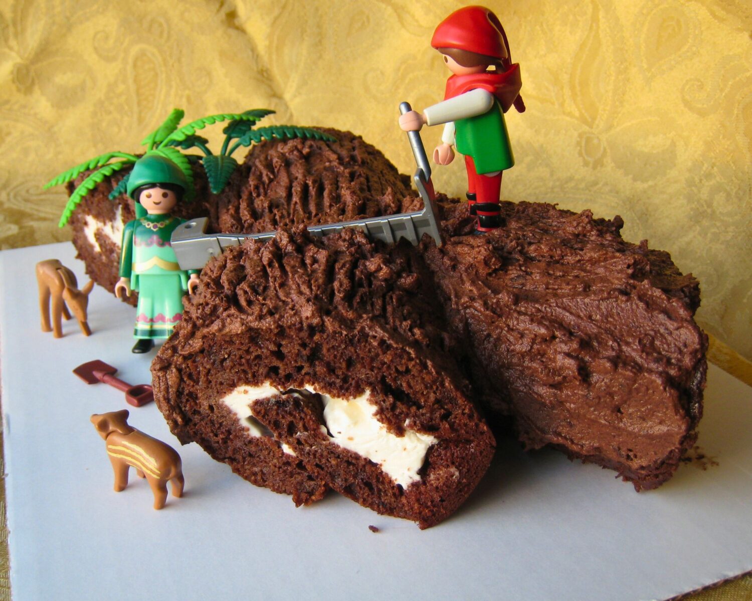 buche de noel with playmobil elves on top.