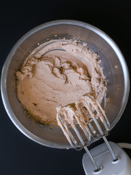 chocolate whipped cream in bowl with beaters.