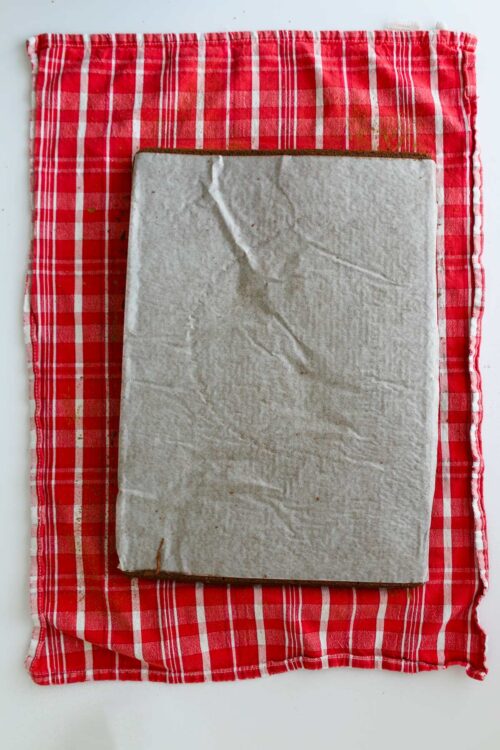 cake inverted on tea towel with parchment paper.