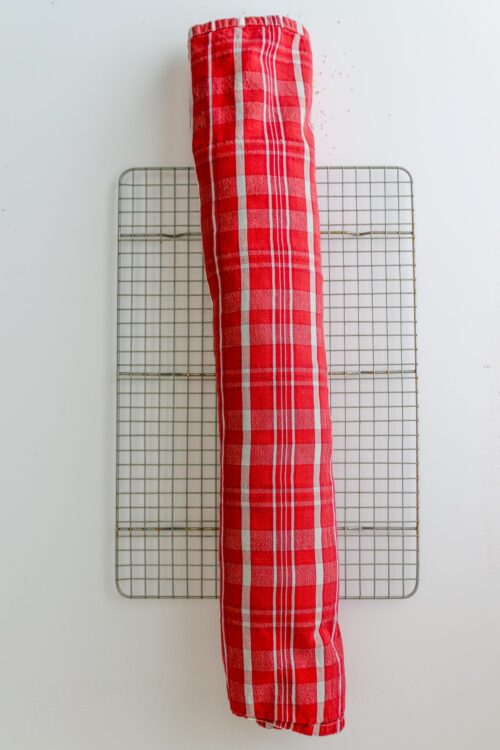 cake rolled in towel cooling on rack.