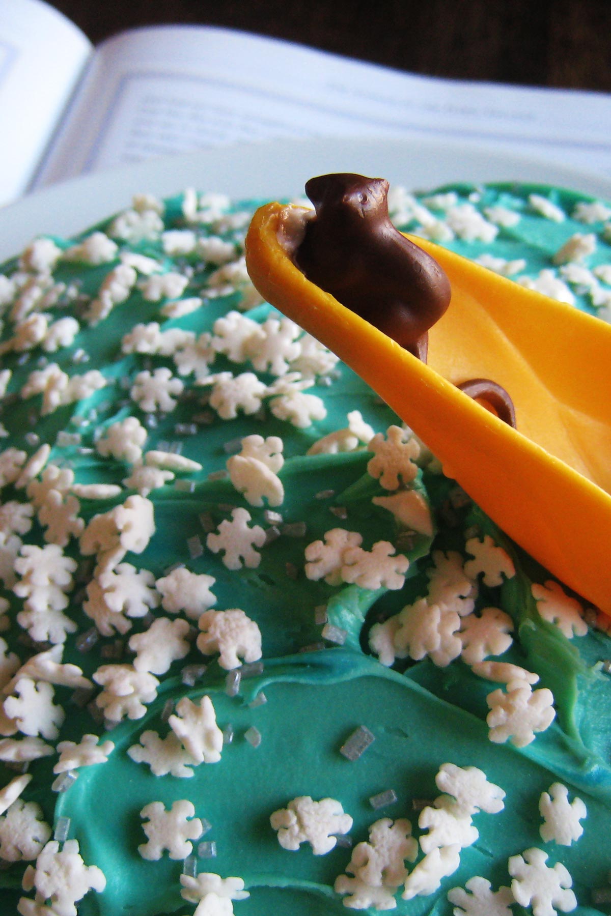 close-up of reepicheep on boat on cake with white flower sprinkles.