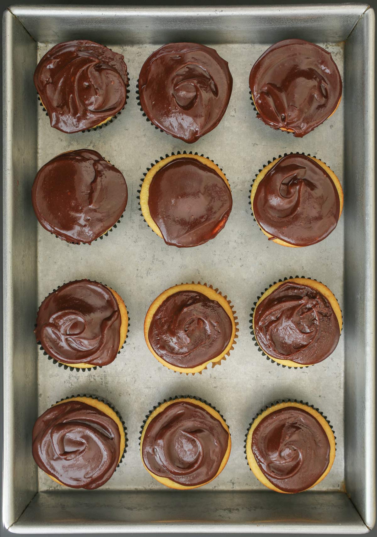 frosted chocolate cupcakes in metal tray.