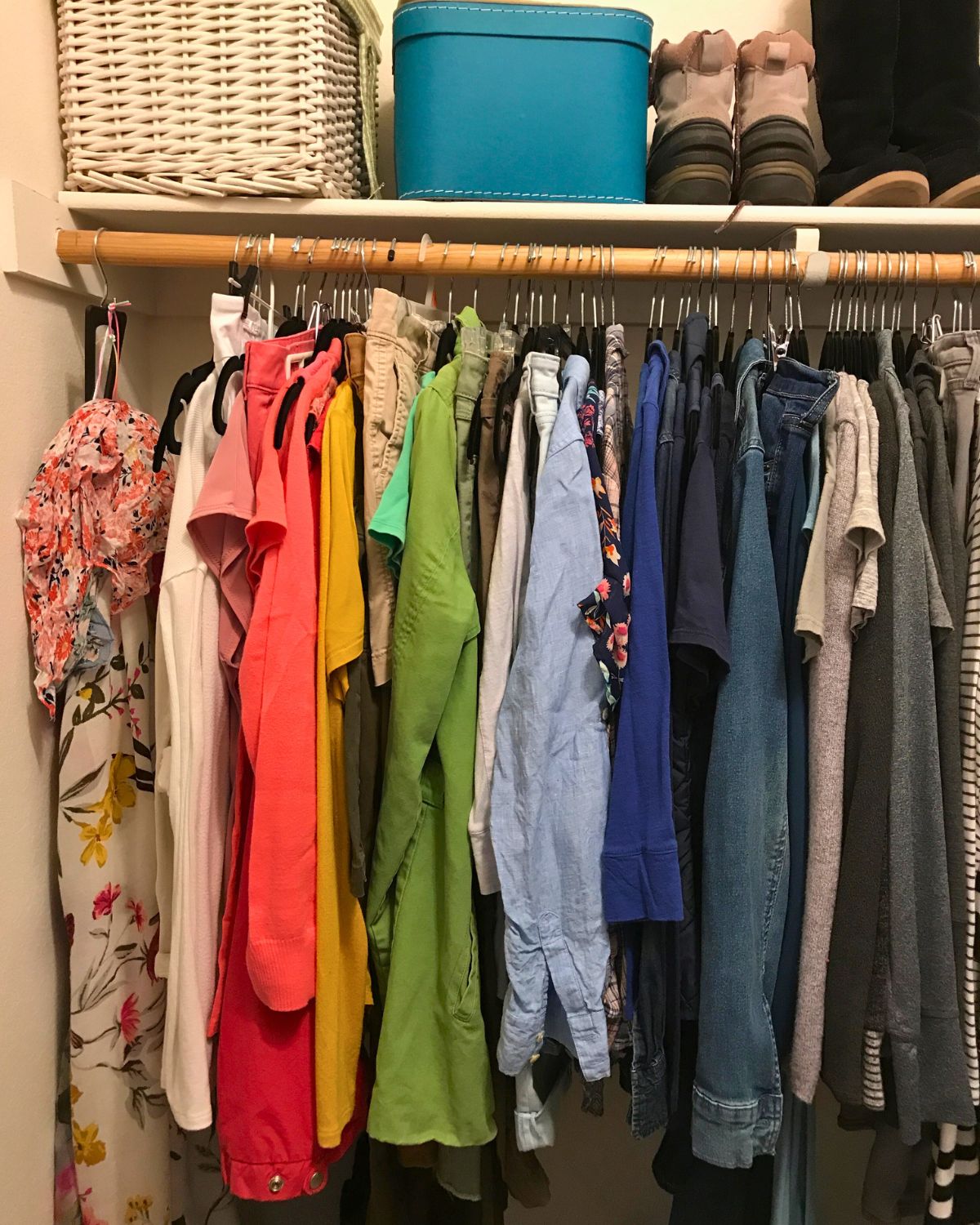 view of clothes organized by color in closet.