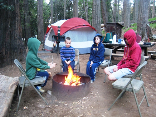 A group of kids sitting by a fire