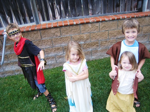 Kids dressed in costumes next to a fence