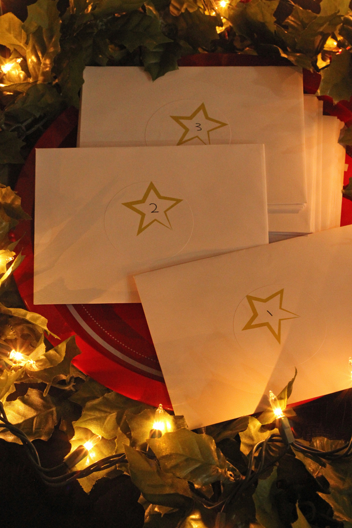Christmas Countdown envelopes on platter with holly and Christmas lights.