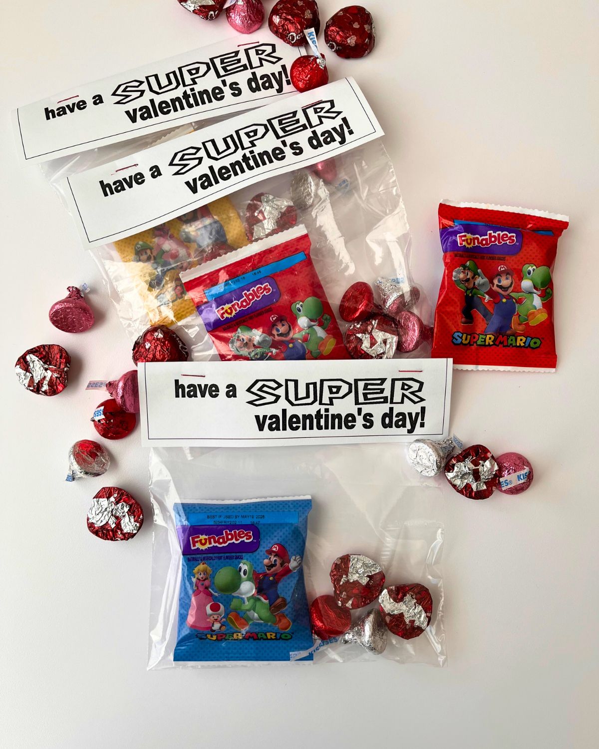 candy scattered on table with super mario valentine bags.