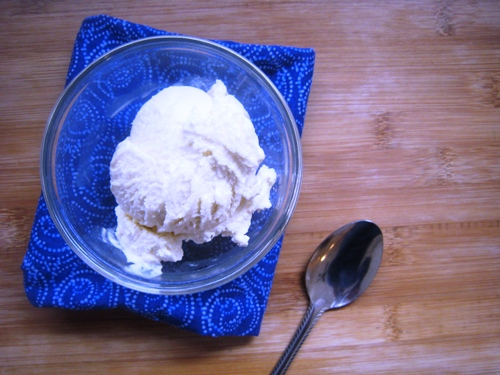 a dish of vanilla ice cream on a table with a spoon