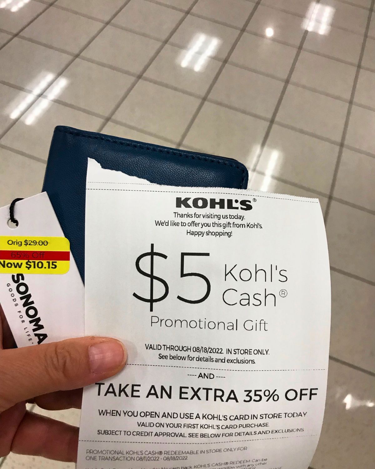 holding clearance wallet with a kohls cash coupon.