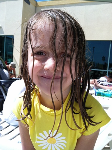 A girl at the pool smiling for the camera