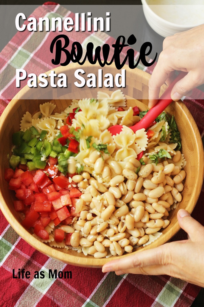 stirring a bowl of bowtie pasta salad 