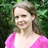 A girl in a pink shirt looking at the camera.