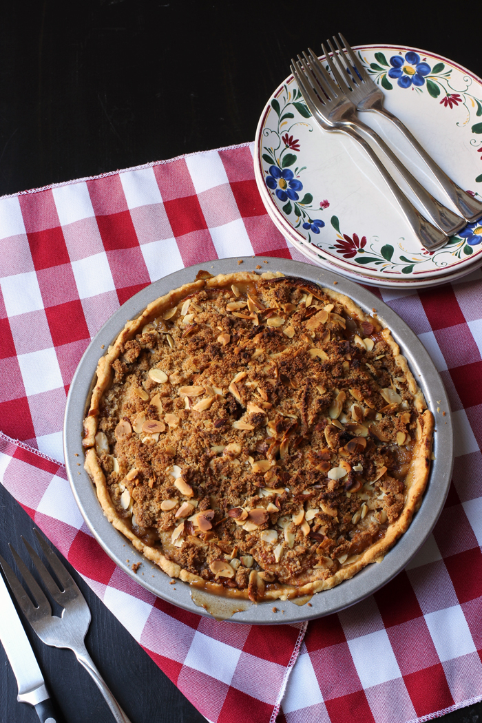 apple pie on checked cloth with plates and forks