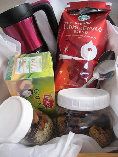 A basket filled with coffee, tea, and breakfast items.