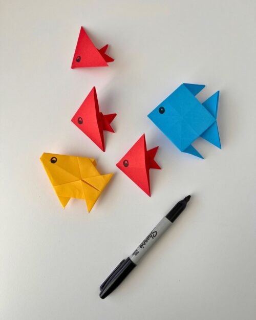 origami fish with sharpie on white surface.