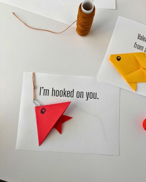 origami fish glued onto white card.