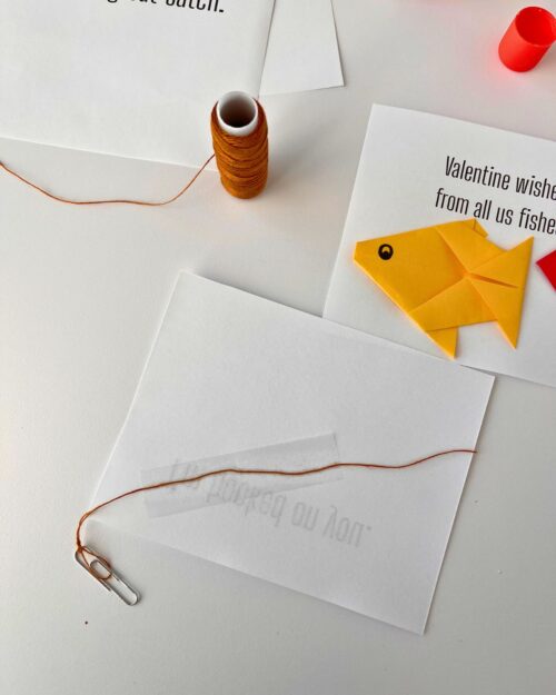 back side of card with paperclip on string taped to the card.