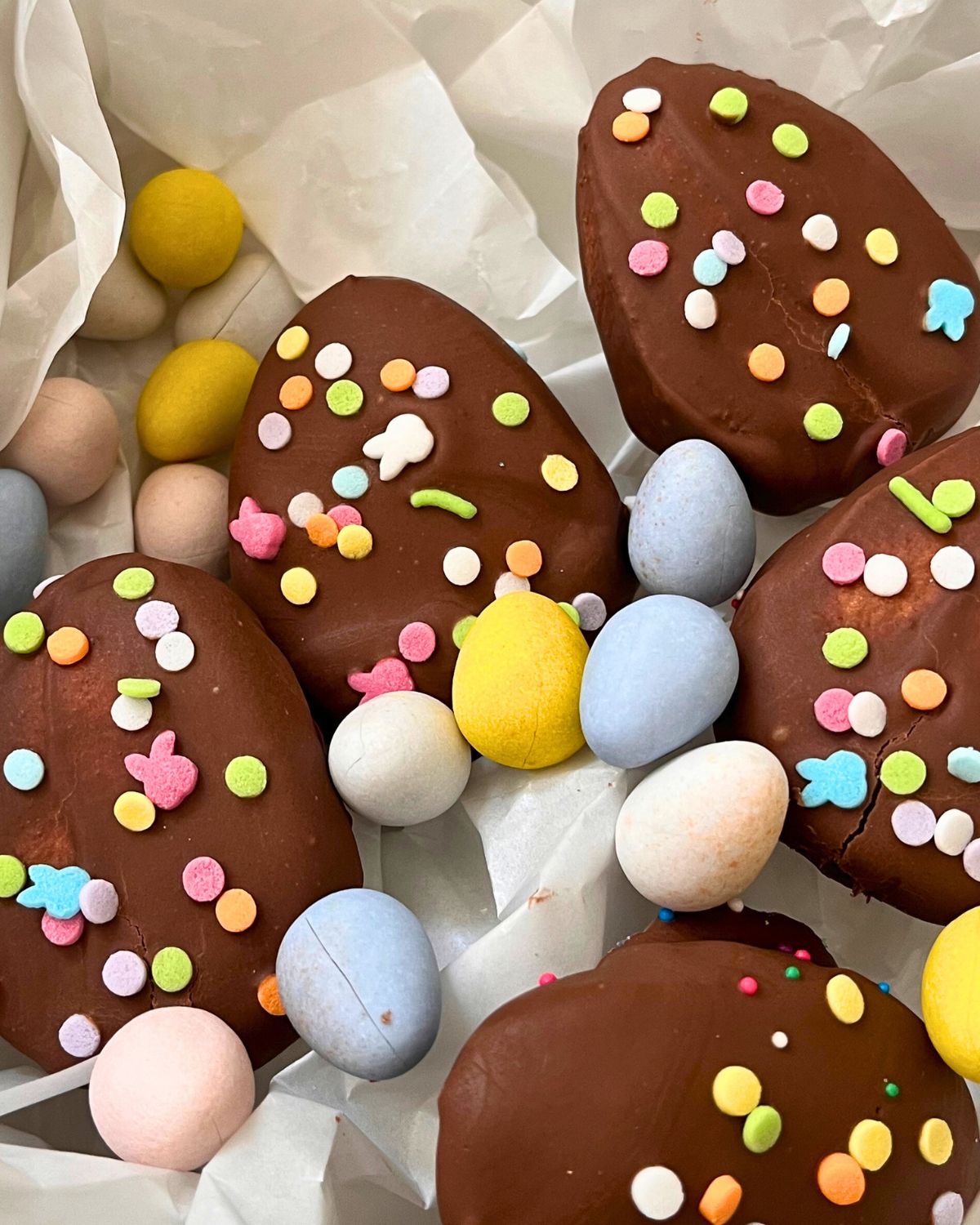 close up of chocolate marshmallow eggs in tin with cadbury eggs.