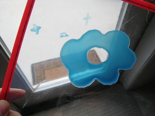 Homemade window cling made into a blue flower.