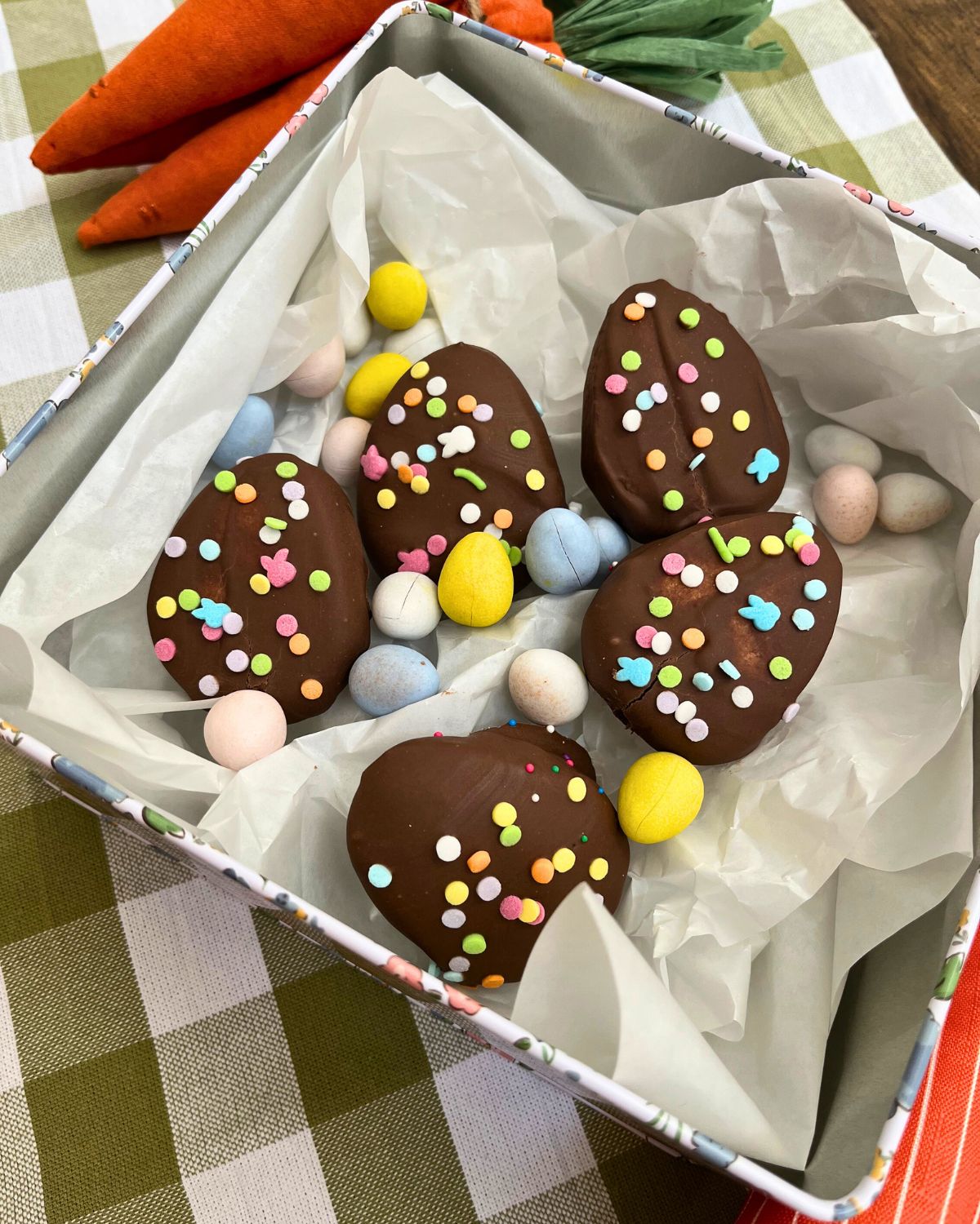 metal tin lined with tissue paper and filled with chocolate eggs and cadbury eggs.